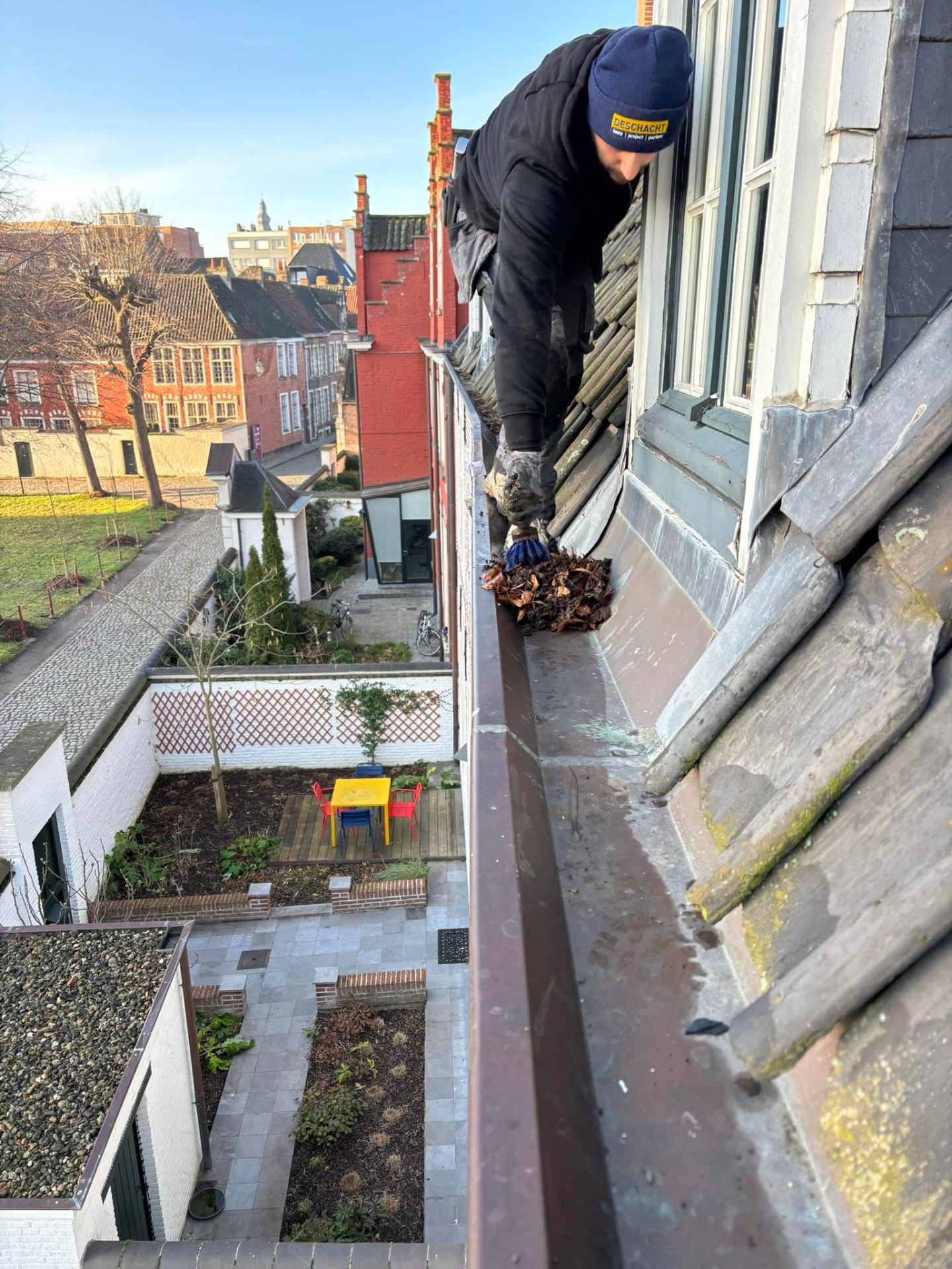 Gootbusters vakman reinigt een dakgoot in Oost-Vlaanderen